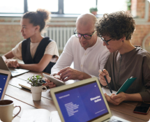 Coworkers collaborating with laptops and tablet