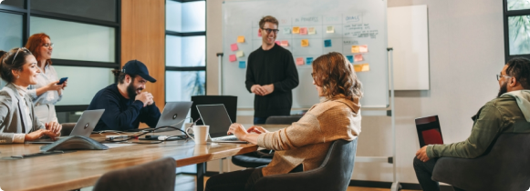 Team meeting with presenter at whiteboard